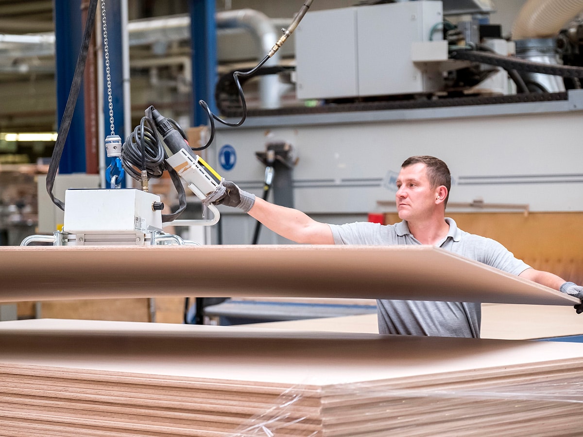 Holzplatte wird mechanisch angehoben, um gesägt zu werden