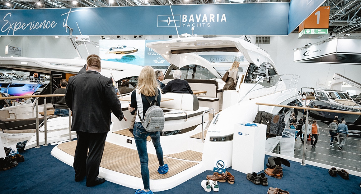 Trade fair visitors explore the SR41 motor yacht from BAVARIA in the exhibition hall.