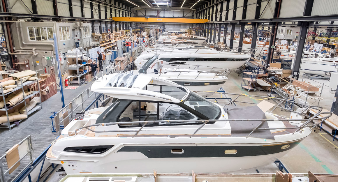 View of a large shipyard with numerous boats in the centre and shelves on the sides.