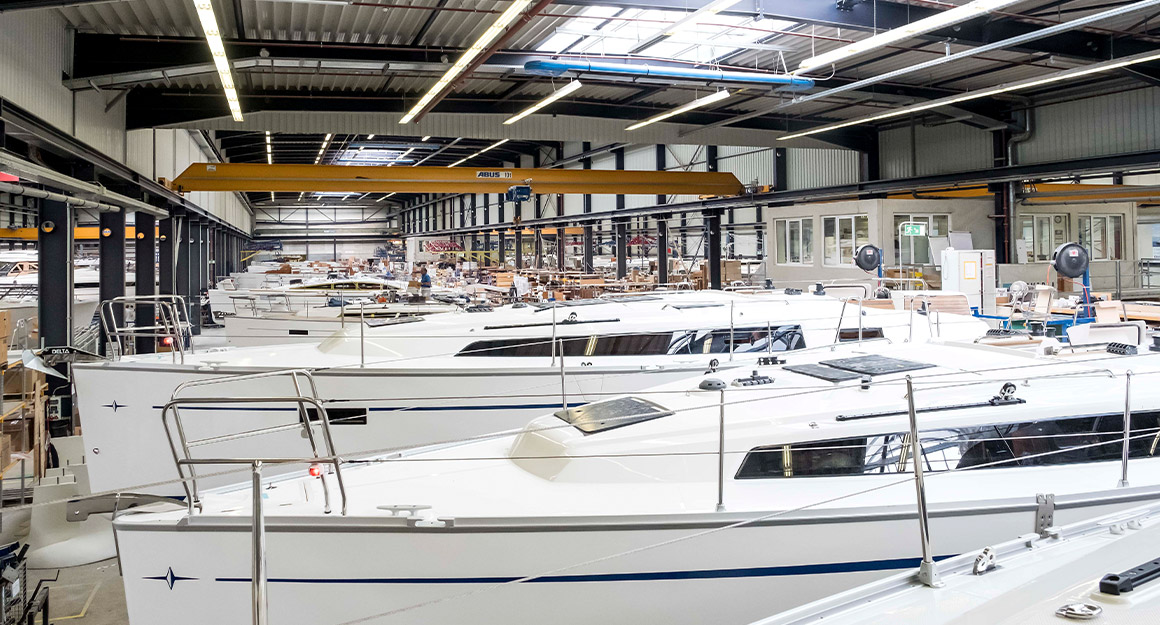 View of a large shipyard with numerous boats in the centre and shelves on the sides.