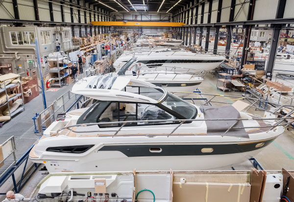 View of a large shipyard with numerous boats in the centre and shelves on the sides.