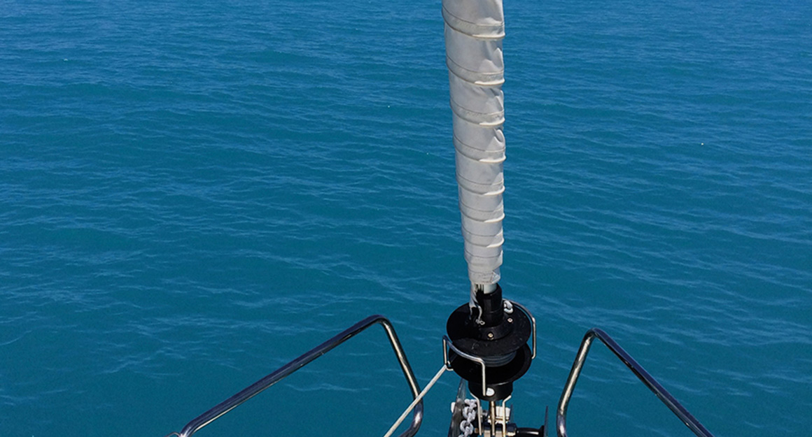 View from the foremost point of a yacht down to the blue sea.