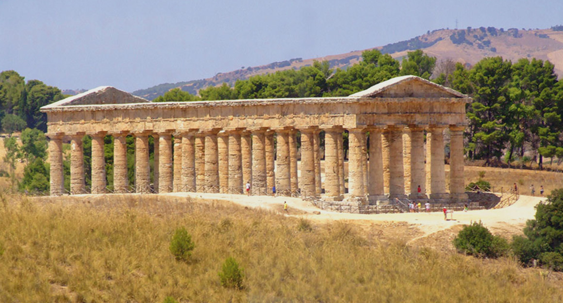 A well-preserved elongated ancient building on columns in the Sicilian plains.