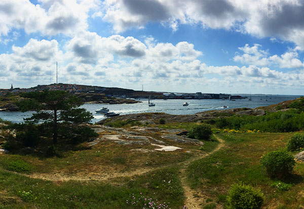 Extensive area with green landscape, clear water and boats as well as a coastal town.