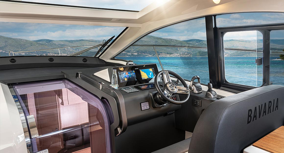 Interior view of the steering position of a motorboat with a view of a bay.