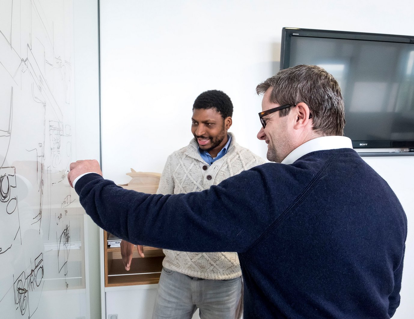 Pascal Kuhn, product manager for sailing yachts at BAVARIA, explains something to a colleague.